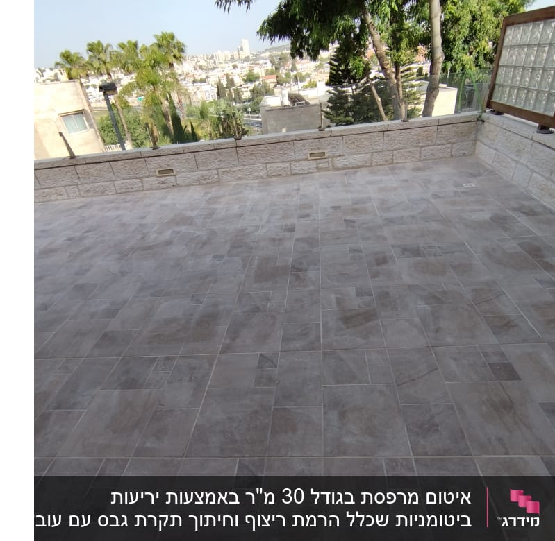 ריצוף חדש על מרפסת עם קיר אבן